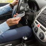 Driver holding mobile phone while driving his car